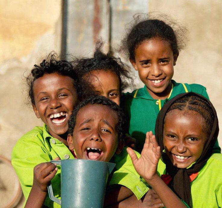Five laughing Somali schoolchildren in green uniforms